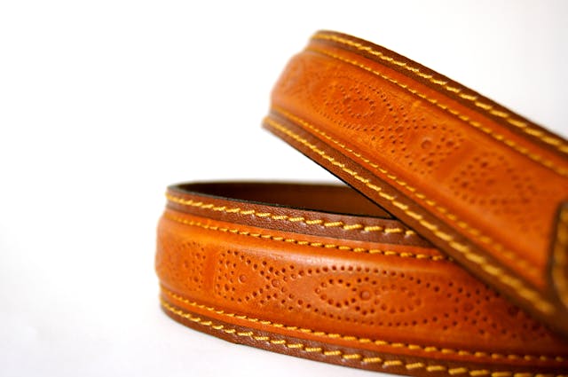 Luxury Hermès belt in signature orange leather with an iconic ‘H’ buckle, symbolizing timeless style and investment-worthy fashion for the modern gentleman.