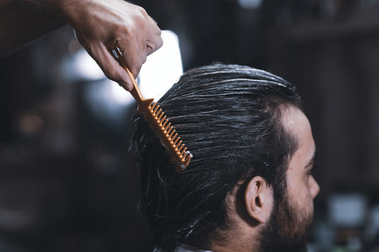 Professional hairstylist applying a non-surgical hair replacement system to a male client at Kaelyss in Chicago, ensuring a natural and seamless look.